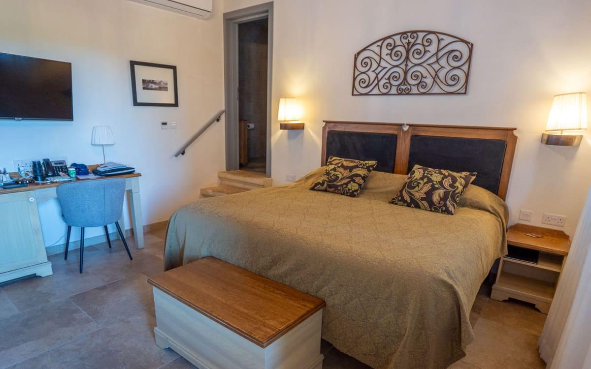 Hotel room with double bed, desk, and TV at the Mulberries Boutique Hotel in Żabbar