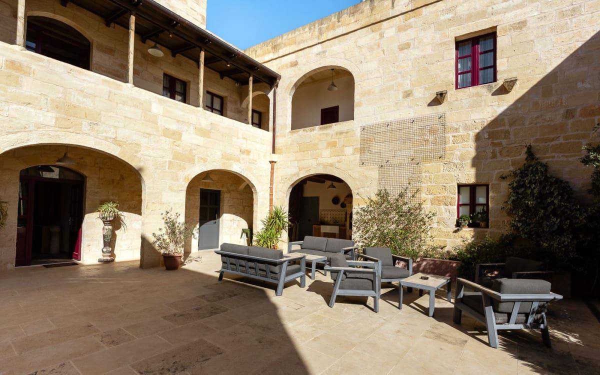 Relaxing in the sunny courtyard of the Mulberries Boutique Hotel - stylish lounge area in the heart of Żabbar, Malta.